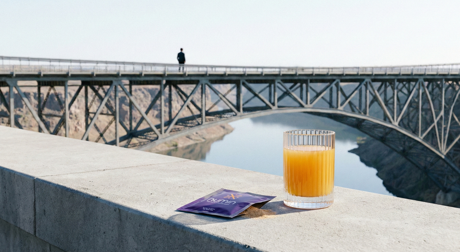Numin nootropic focus drink and sachet on a stone ledge above a canyon bridge.