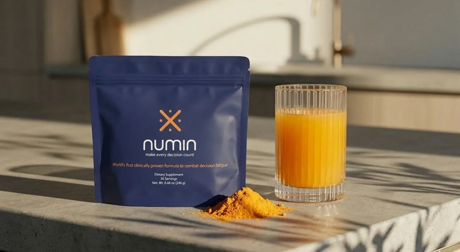 Numin decision fatigue supplement pouch beside orange drink and powder on a sunlit counter.
