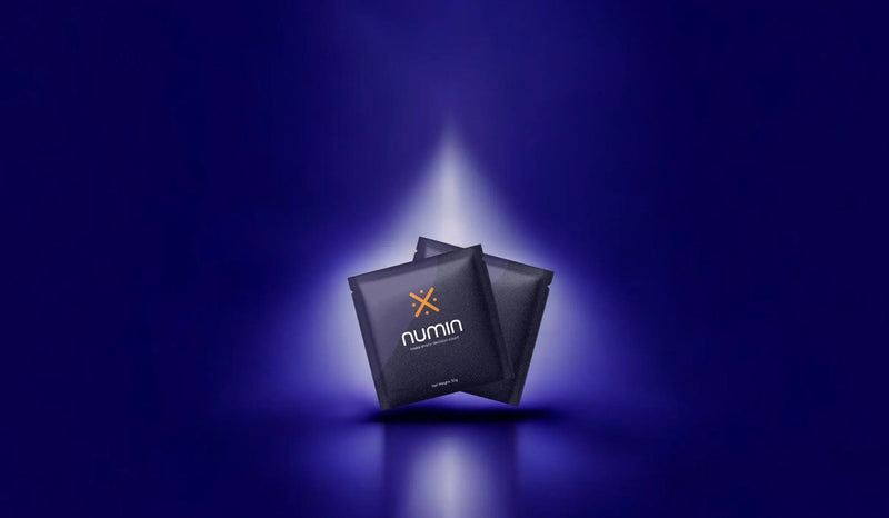 Brain drink sachets by Numin featured under a spotlight on a dark blue background.