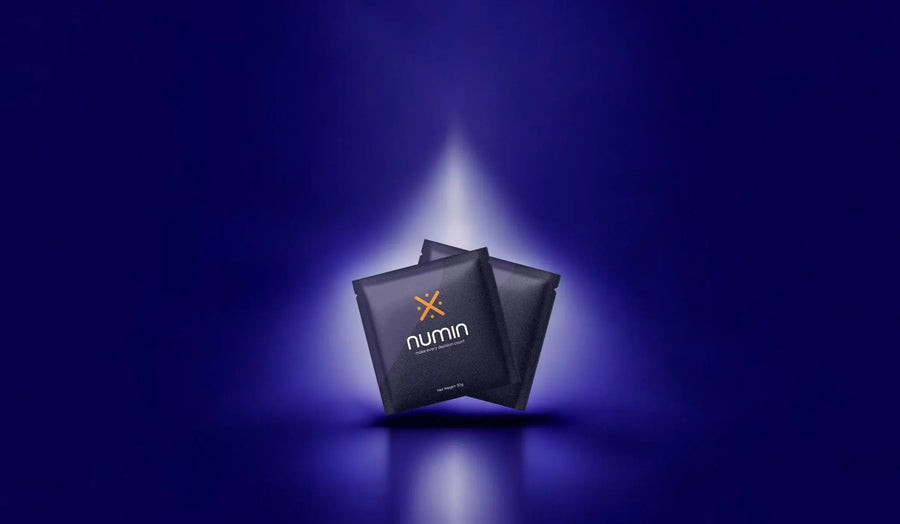 Glutamate supplements in sleek black Numin sachets spotlighted against a deep blue background for a premium look.