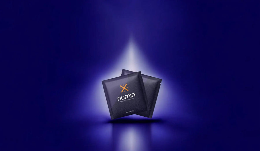 Mental clarity supplements Numin packets illuminated by a focused beam of light against a deep blue background symbolizing enhanced cognition