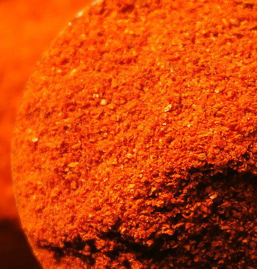 Macro close-up of orange Numin powder mounded high, a decision fatigue supplement.