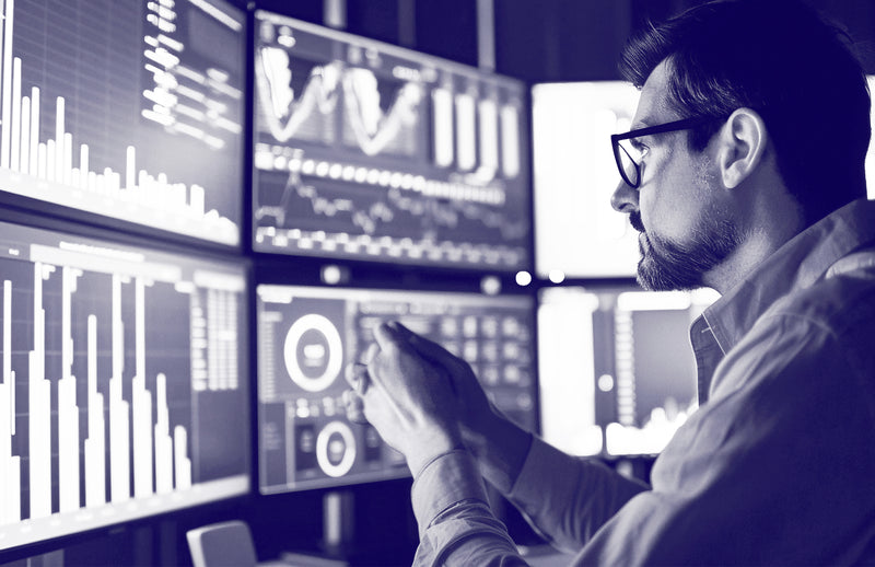 Man analyzing data charts and graphs on multiple screens, representing mental decision fatigue solutions