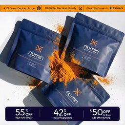 Three blue Numin brain supplement powder pouches with orange turmeric spilling out on white surface
