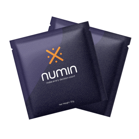 Two purple Numin brain fog supplement packets showing the orange logo and product branding