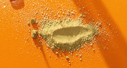 Orange surface with white brain supplement powder scattered in an oval shape