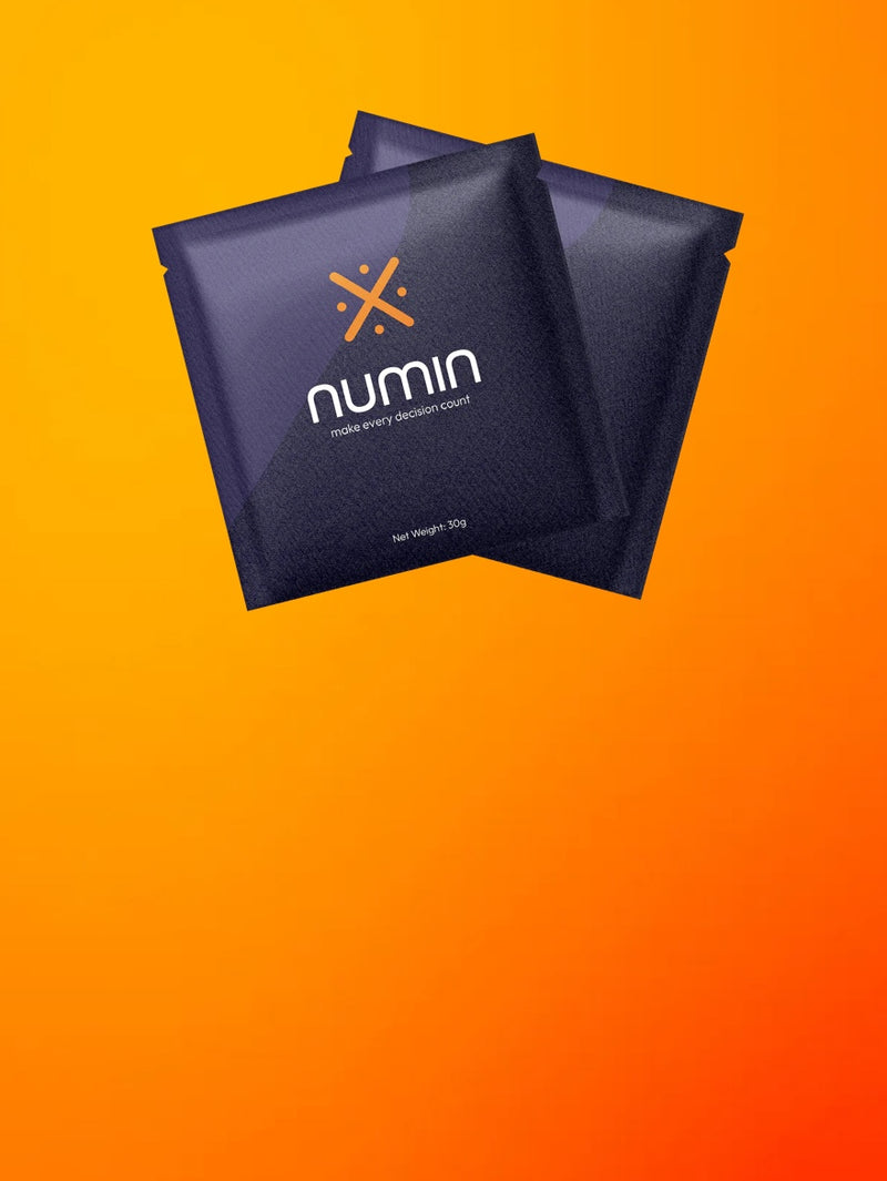 Two dark purple Numin brain drink packets on orange background showing product packaging