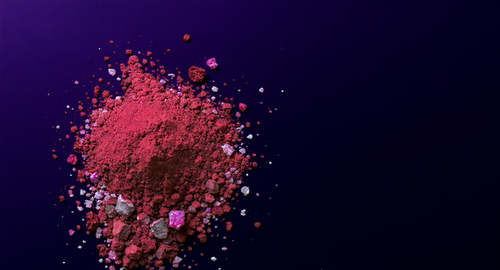 Pink and purple brain supplement powder scattered on dark background