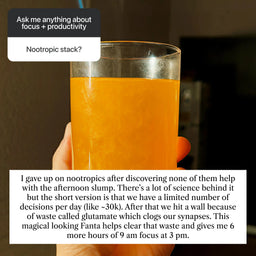 Hand holding glass of orange afternoon focus drink with text about productivity and decision fatigue