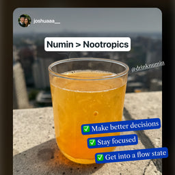 Glass of orange Numin nootropic drink supplement on stone ledge with benefits listed: better decisions, focus