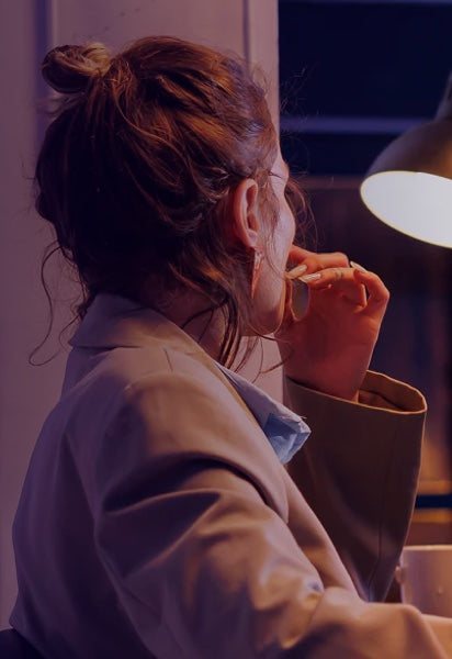 Woman in bathrobe drinking from mug while experiencing mental exhaustion from daily decision making